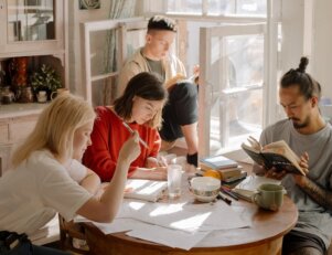 jovens se reúnem em uma mesa para estudar