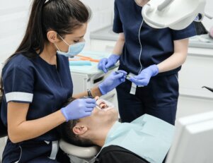 dentistas no consultório atenden um paciente, saiba mais sobre o vestibular de odontologia
