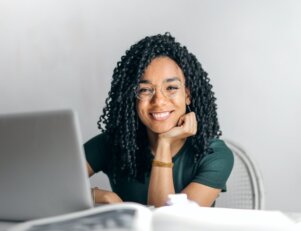 mulher negra estudante do curso de história sentada na mesa de frente ao notebook