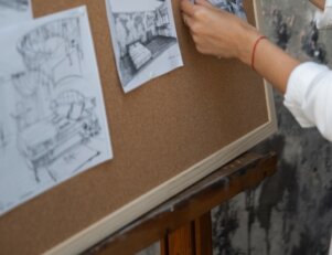 Mulher colocando ideias para Design de Interiores em um quadro