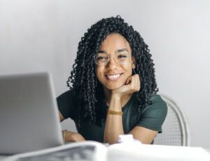 mulher negra estudante do curso de história sentada na mesa de frente ao notebook