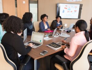 Várias pessoas sentadas ao redor de uma mesa
